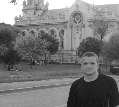 Picture of Stewart with ornate building in background.