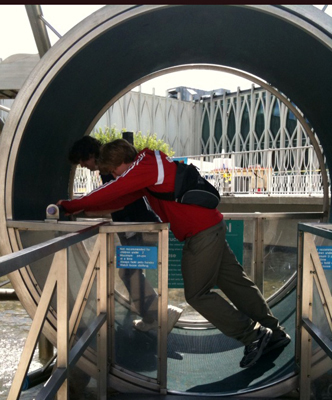 Picture of Josh and Lewis inside a large water wheel.