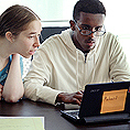 Image of a mentor helping a student on a laptop