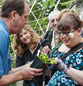 A blind student feels a venus fly trap that an instructor is handing her.