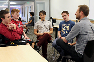 Summer study students sit with a mentor.