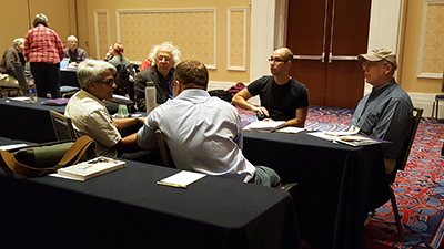 Participants of the AccessCS10K CBI gather around a table, discussing ideas.