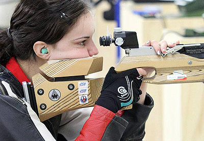 Photo of McKenna looking through the viewfinder on a competition rifle