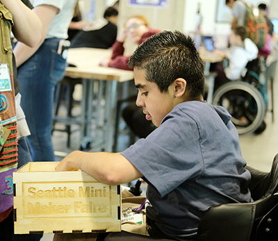 A student looks through a box of 3D printed objects.