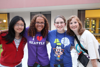 Photo of four DO-IT Scholars pose arm in arm outside UW's McCarty dorms during Summer Study 2012.