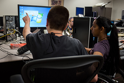 Two students working together on a computer.