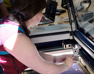 A student feels the innerworkings of a laser cutter.