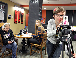 Image of students doing a filming activity in a student lounge