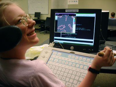 A high school student uses assistive technology with her laptop.