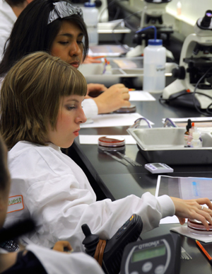 Image of a student conducting a science experiment in a lab.